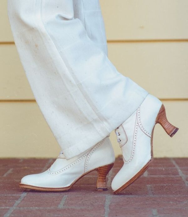 A woman wearing white pants and white shoes.