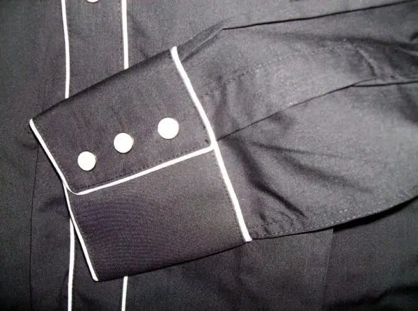 A close up of a black shirt with white buttons.