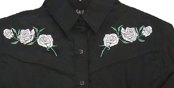 A black shirt with white roses embroidered on it.