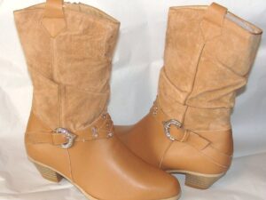 A pair of tan cowboy boots with buckles.