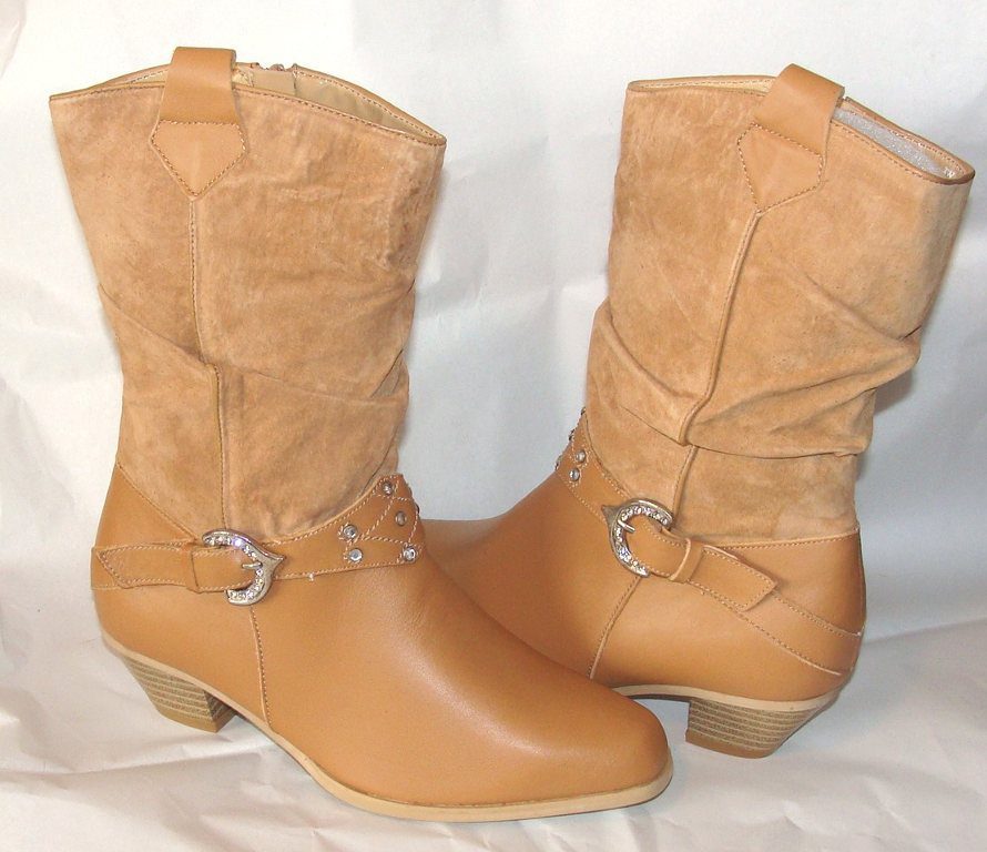 A pair of tan cowboy boots with buckles.