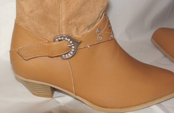 A pair of tan boots with a buckle on the side.