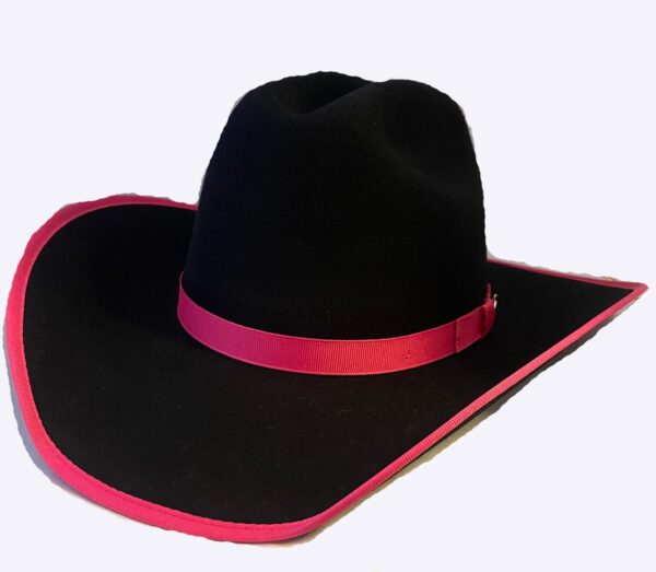Black cowboy hat with pink border on the display