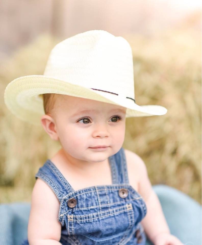 Baby wearing denim outfit and cream hat