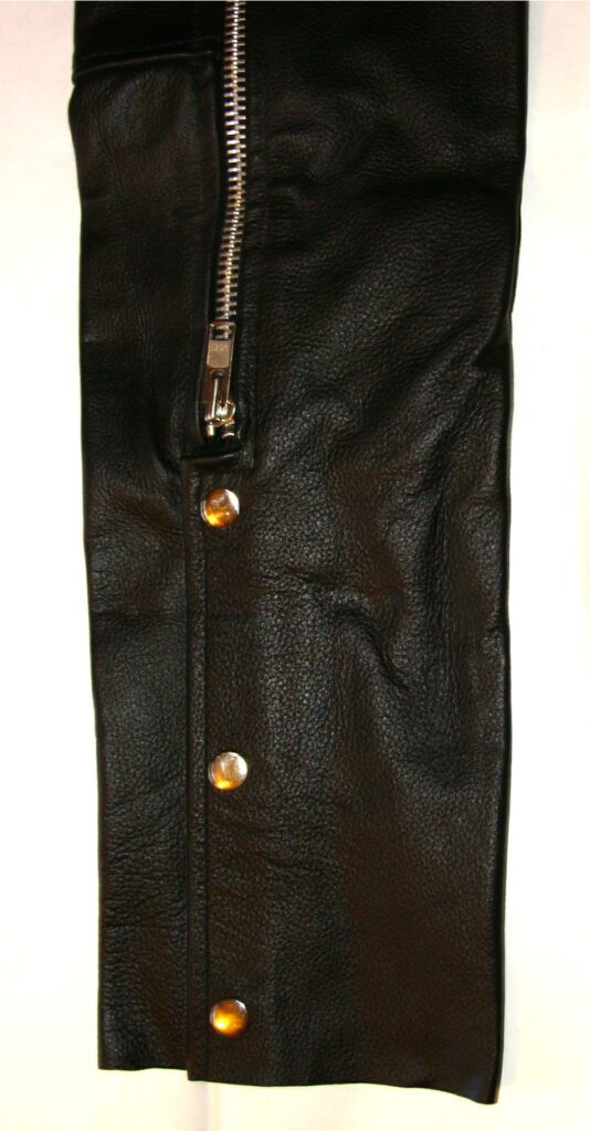 A pair of Child Smooth Black leather chaps with gold zippers.