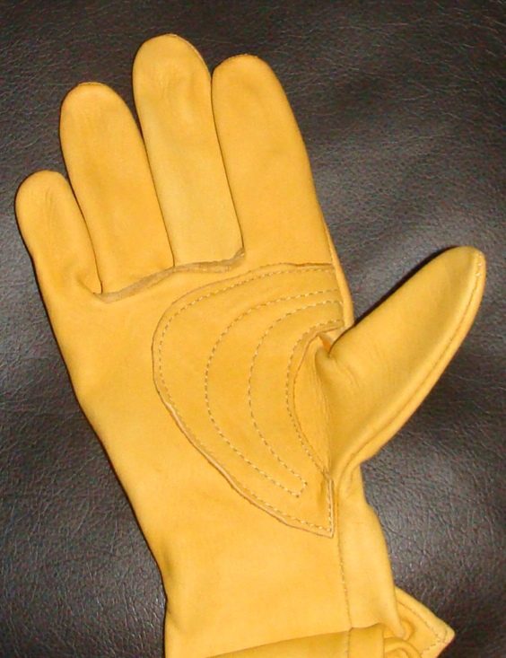 A pair of Deerskin leather western riding Roper gloves USA made on a leather surface.