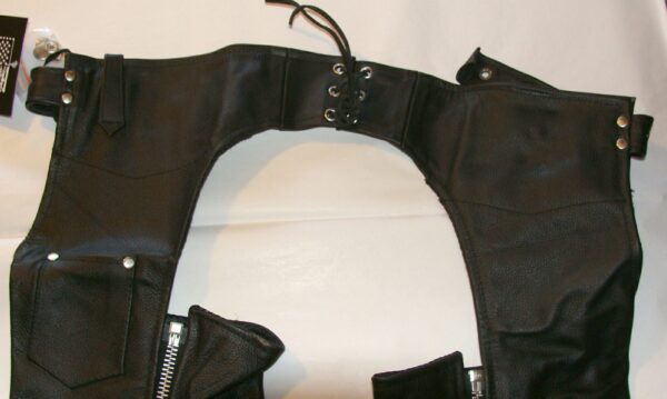 A pair of Child Smooth Black leather chaps with zippers and zippers.