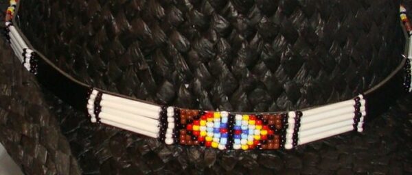 A hat with a beaded belt on it.
