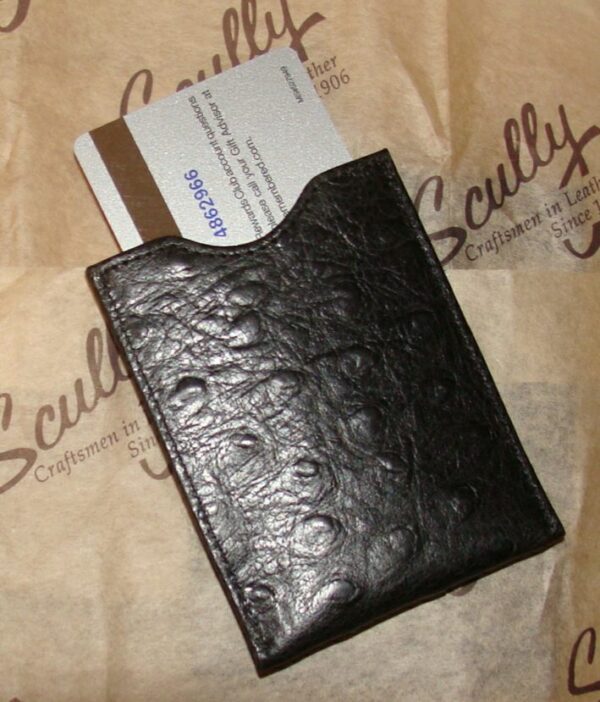 A Scully Black Ostrich leather magnetic money clip with a business card inside.