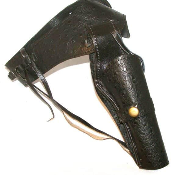 A .38 Caliber Black Tooled Leather Single Western Gun Holster with a gold buckle.