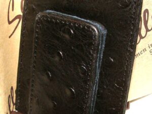 A Scully Black Ostrich leather magnetic money clip with ostrich leather on top.