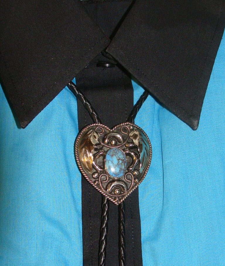 A Turquoise Stone Heart Shaped Silver Bolo Tie with a heart shaped brooch on it.