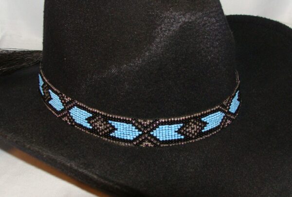 A black cowboy hat with a blue beaded Horse hair tassel Navajo hat band.