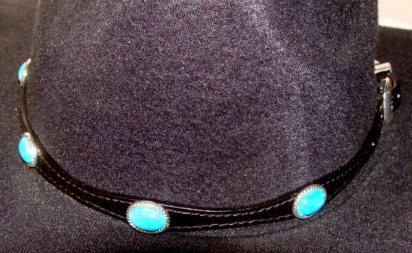 A Sterling Silver Buckle Turquoise stone black leather hat band with turquoise stones on it.