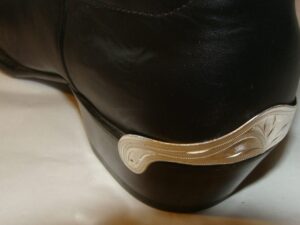 A black cowboy boot with a silver buckle.