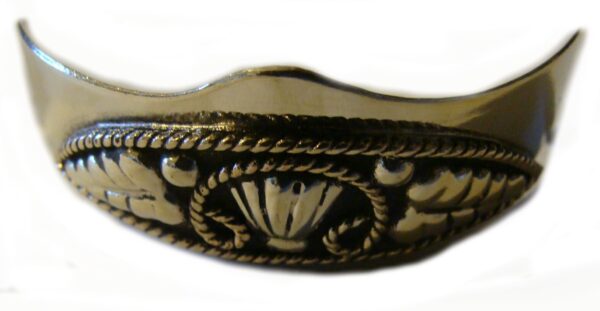 A Vine filigree Silver Cowboy boot heel guards with a design on it.