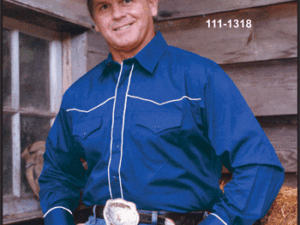 A man wearing a Mens White piped yoke, Royal blue western shirt and cowboy hat.