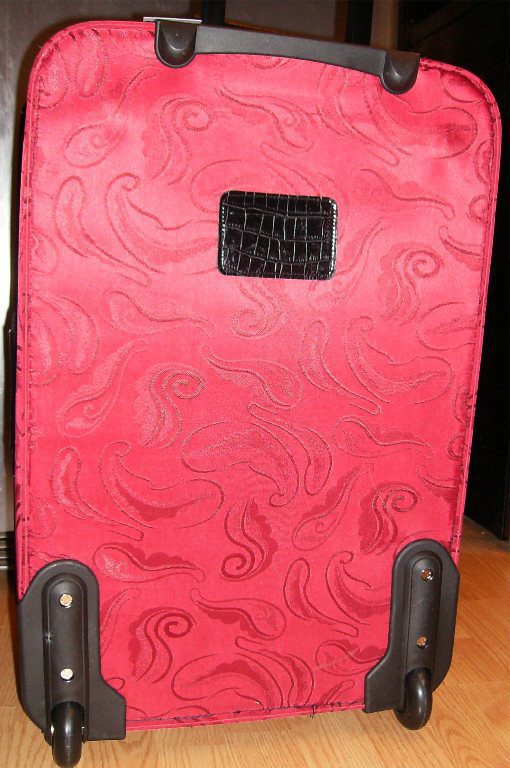 A 21" Red & Black croc print leather rolling carry on luggage set sitting on a wooden floor.