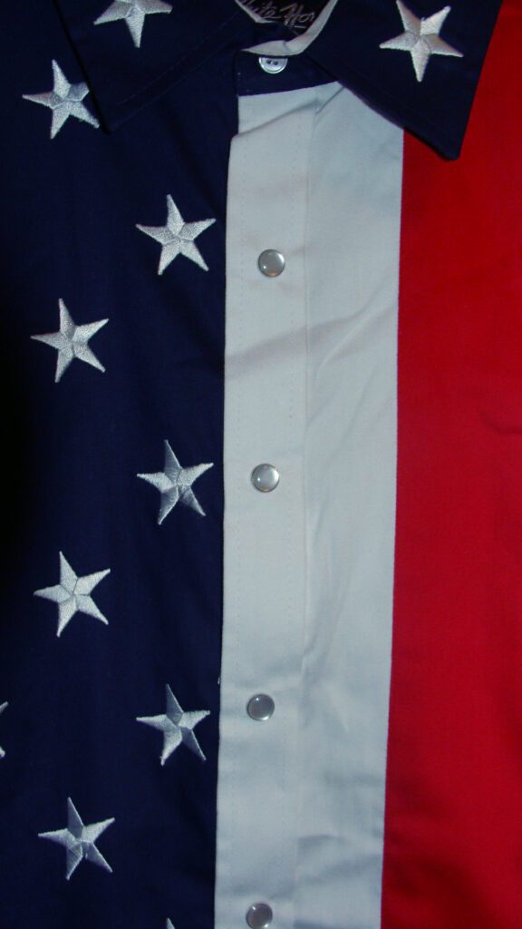 A close up of a Ladies Red White, Blue American Flag pearl snap western shirt.