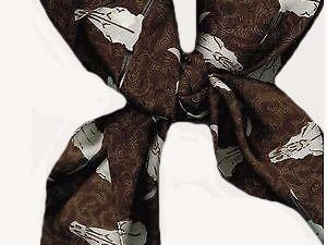 A brown and white USA MADE Steer Head Skull Silk Western Scarf with cow skulls on it.