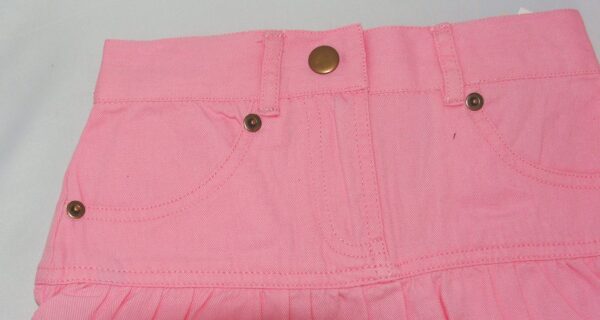 A Girls 3/4 Length Pink Denim Western Skirt with buttons on it.