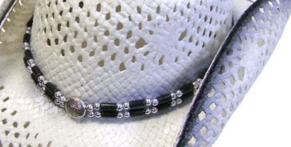 A Nante Pinch Front Gray Stained White Straw Cowboy Hat with a black and white beaded necklace.