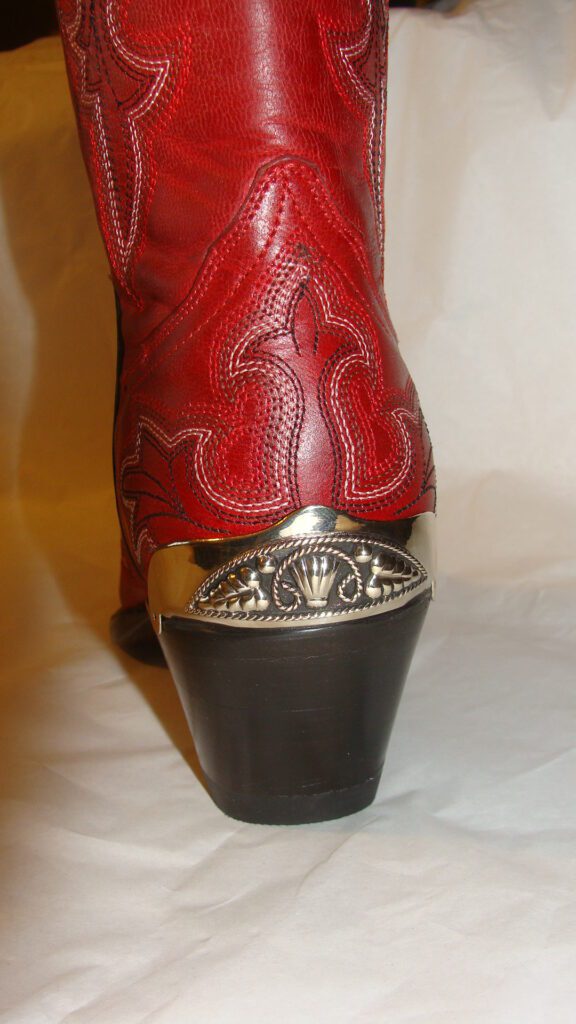 A pair of red cowboy boots with Vine filigree Silver Cowboy boot heel guards.