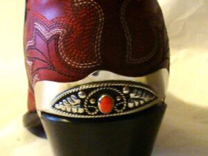 A pair of Red Coral stone Silver Cowboy boot heel guards with a silver buckle.
