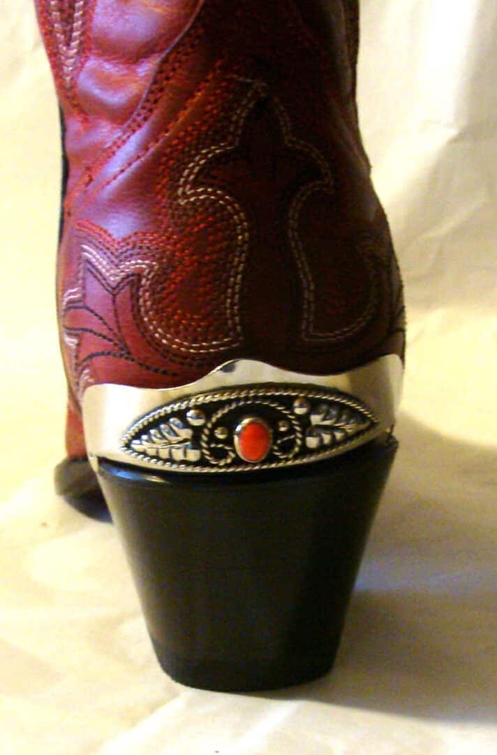 A pair of Red Coral stone Silver Cowboy boot heel guards with a silver buckle.