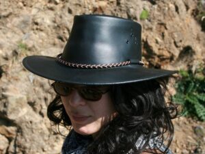 A woman wearing a "Packer" Black or Brown leather cowboy hat by Kakadu.