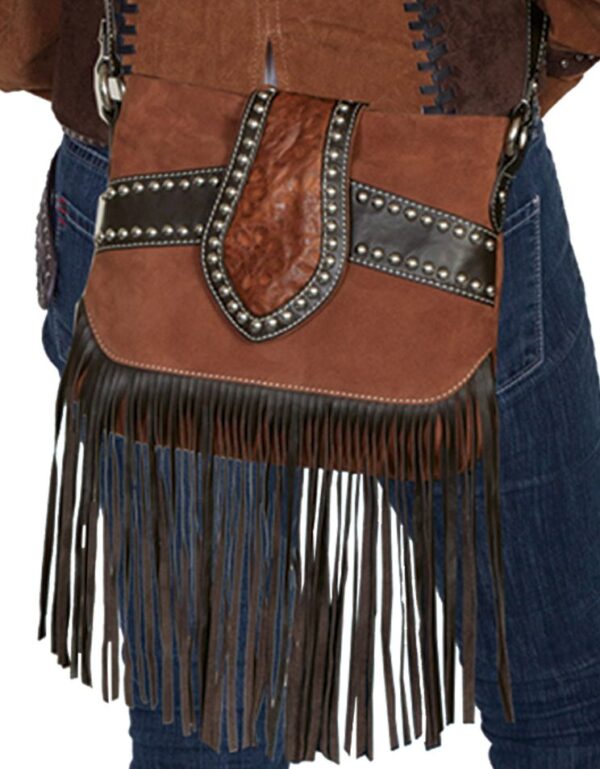 A woman wearing jeans and a Brown Leather, Suede Studded Scully Womens Fringe Handbag, Purse.