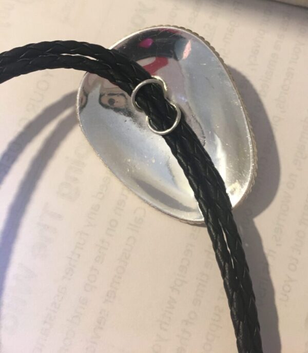A black leather "Big Jim" Large Silver western bolo tie with a silver plate on it.