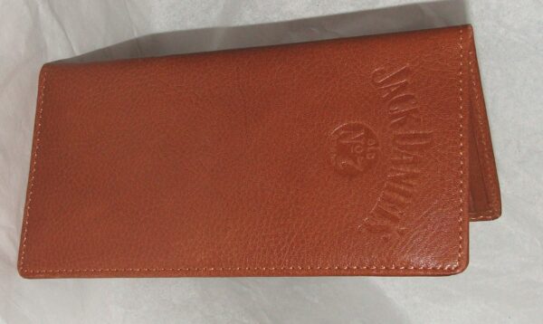 A whiskey "Signature Rodeo" Jack Daniels checkbook wallet is sitting on a white sheet.