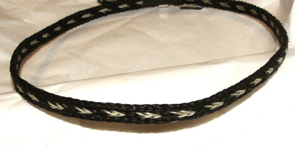 A Sterling Silver Buckle Black Horse hair hat band on a piece of paper.