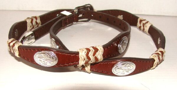 A pair of brown leather collars with silver buckles.
