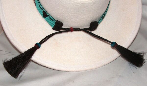 A Turquoise Longhorn Beaded Horse Hair Tassel Cowboy Hat Band with tassels and tassels.