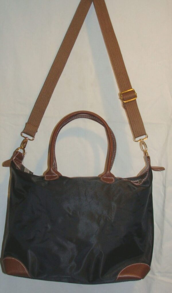 The Wild Cowgirl" Cross-body Black Handbag with brown straps hanging on a white background.