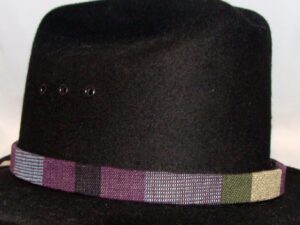 A black hat with a Tapestry Purple Southwestern Cowboy Hat Band.
