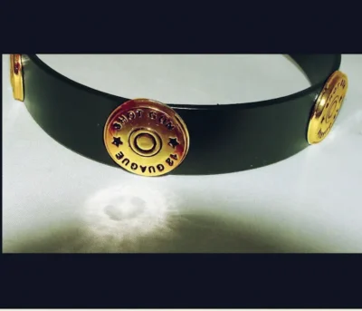 A gold shotgun shell black leather cowboy hat band with bullets on it, featuring a cowboy hat band made of brown leather.