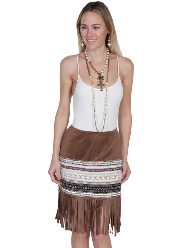 A woman wearing a Scully Womens 70's Style Tan Fringe Western Skirt.