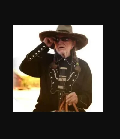 A man wearing a cowboy hat and sunglasses walks by, dressed in a Mens Scully Black Bib Embroidered Guitar Shirt.
