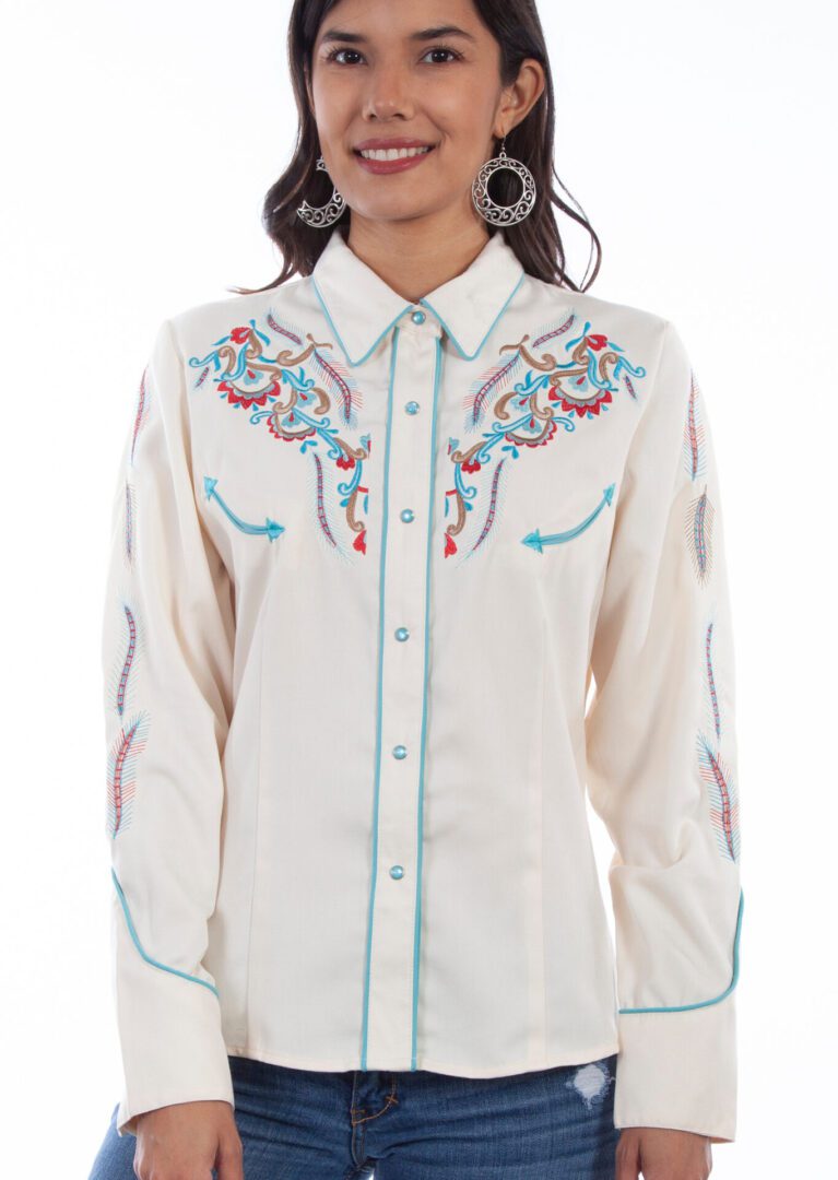 A woman wearing a Scully Women's Embroidered Feathers Cream Denim Western Shirt with turquoise embroidery.