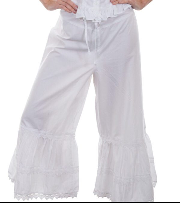 A woman in white ruffled pants posing for a photo.