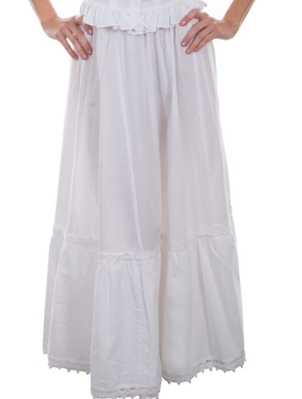 A woman wearing a white dress with ruffles.