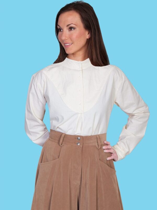 A woman wearing a Ladies Scully Embroidered Bib front Ivory 1800's Blouse and tan pants.