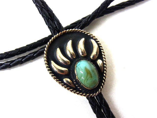 A bolo tie with a Turquoise Stone Silver Raised Bear Claw and a black cord.