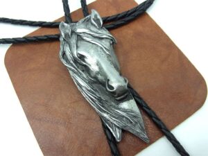 A Vintage Western Horse Head Bolo Tie on a leather strap.