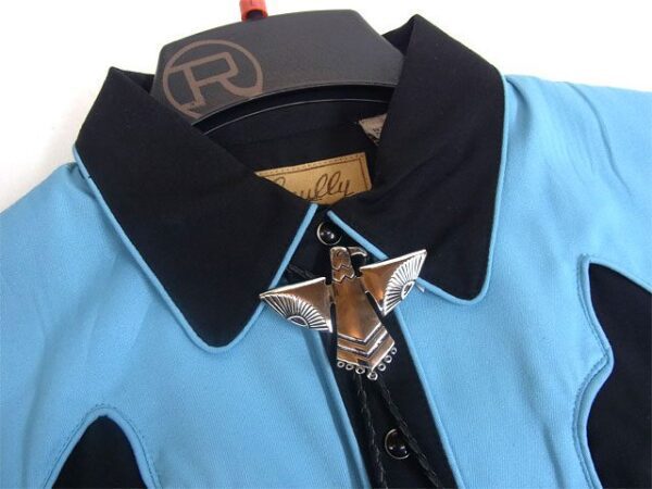 A blue and black Silver Western Phoenix Bolo Tie with a brooch on it.