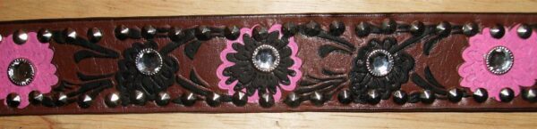 A Brown tooled floral leather rhinestone western belt with pink and brown flowers on it.