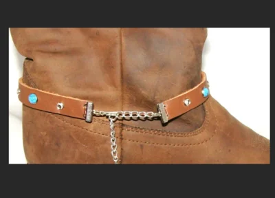 <div class="qsc-html-content"> Brown Leather Cowboy boot bracelet <ul style="list-style: square inside none;"> <li>rhinestone and turquoise studded</li> <li>Sold as 1 each</li> <li>adjustable chain</li> <li>USA MADE</li> </ul> •